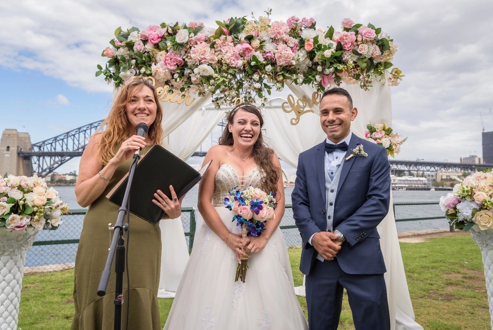 wedding couple and floral arrangement with harbour bridge in background